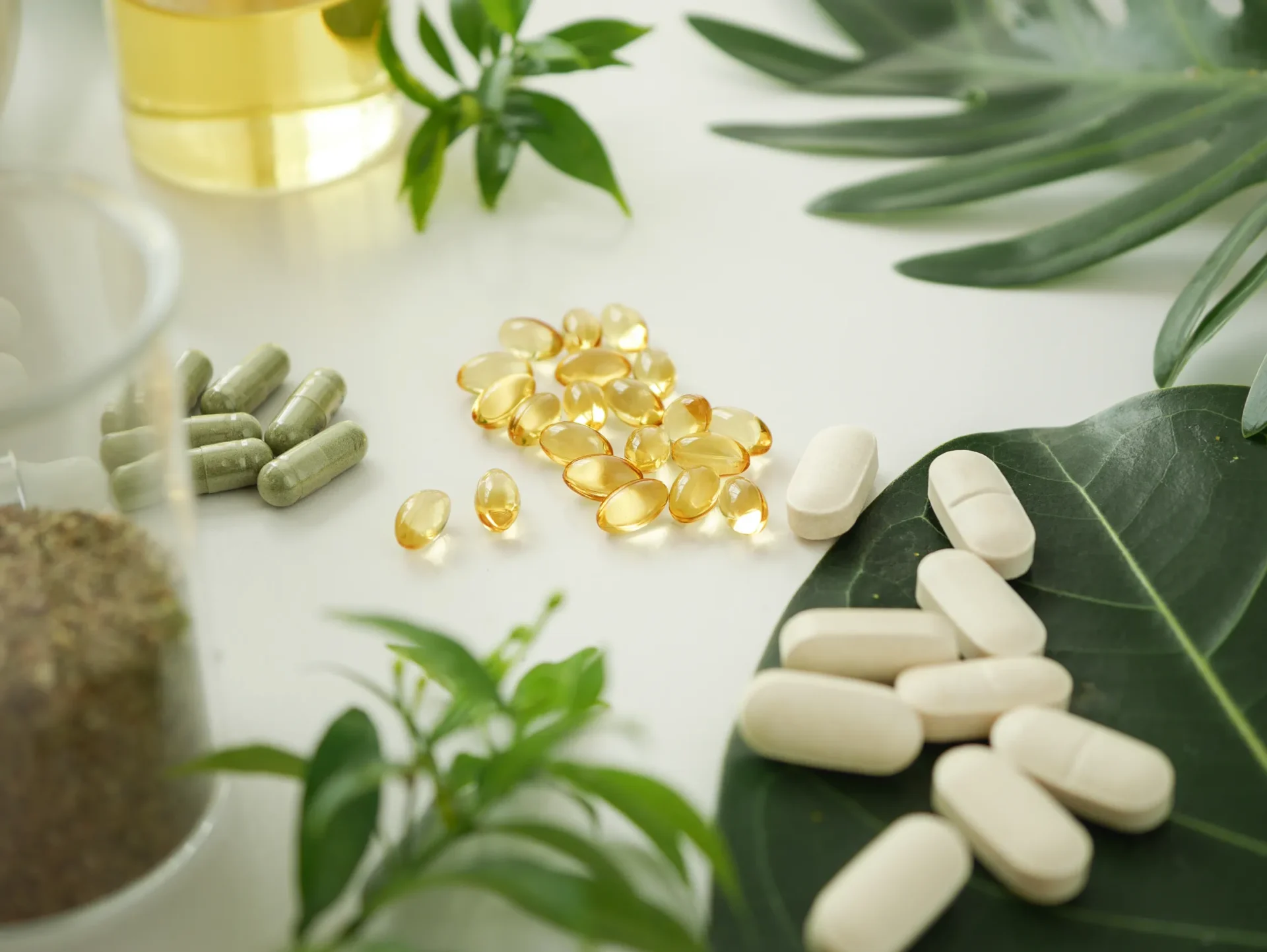 Herbal supplements and pills on leaves.