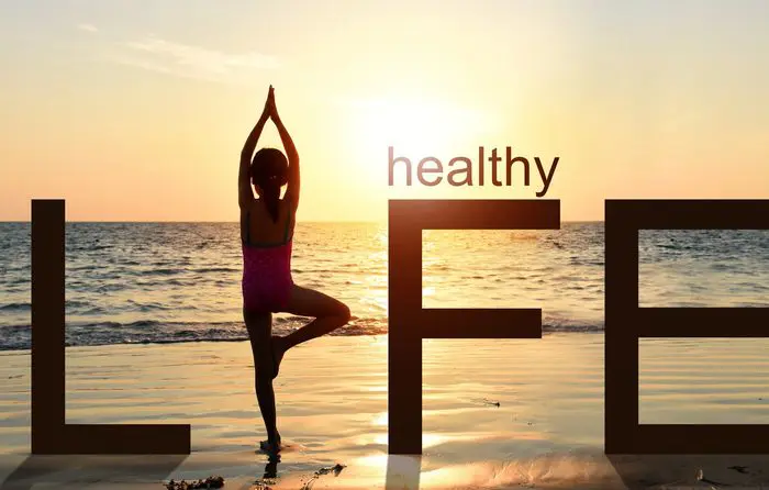 hero A woman is doing yoga on the beach