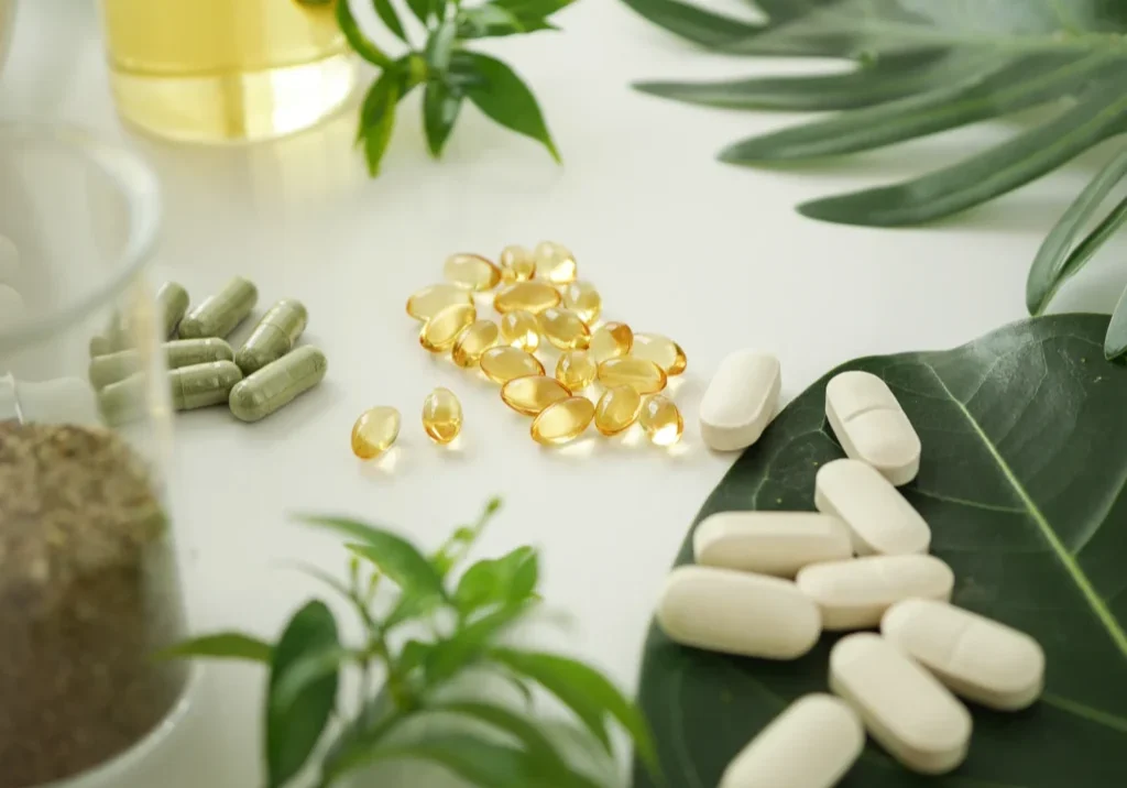 Herbal supplements and pills on leaves.